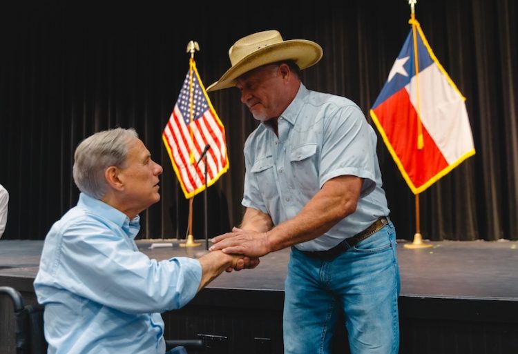 Governor Greg Abbott helps distribute flood relief funds to Hill Country families affected by catastrophic storms